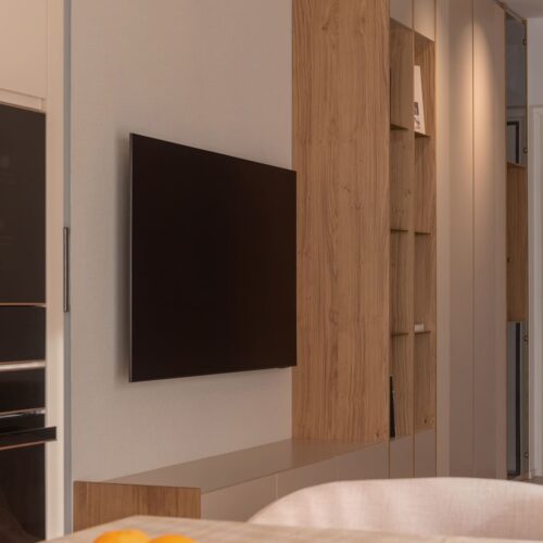 Soggiorno open space con arredi su misura e palette cromatica calda a Rimini.